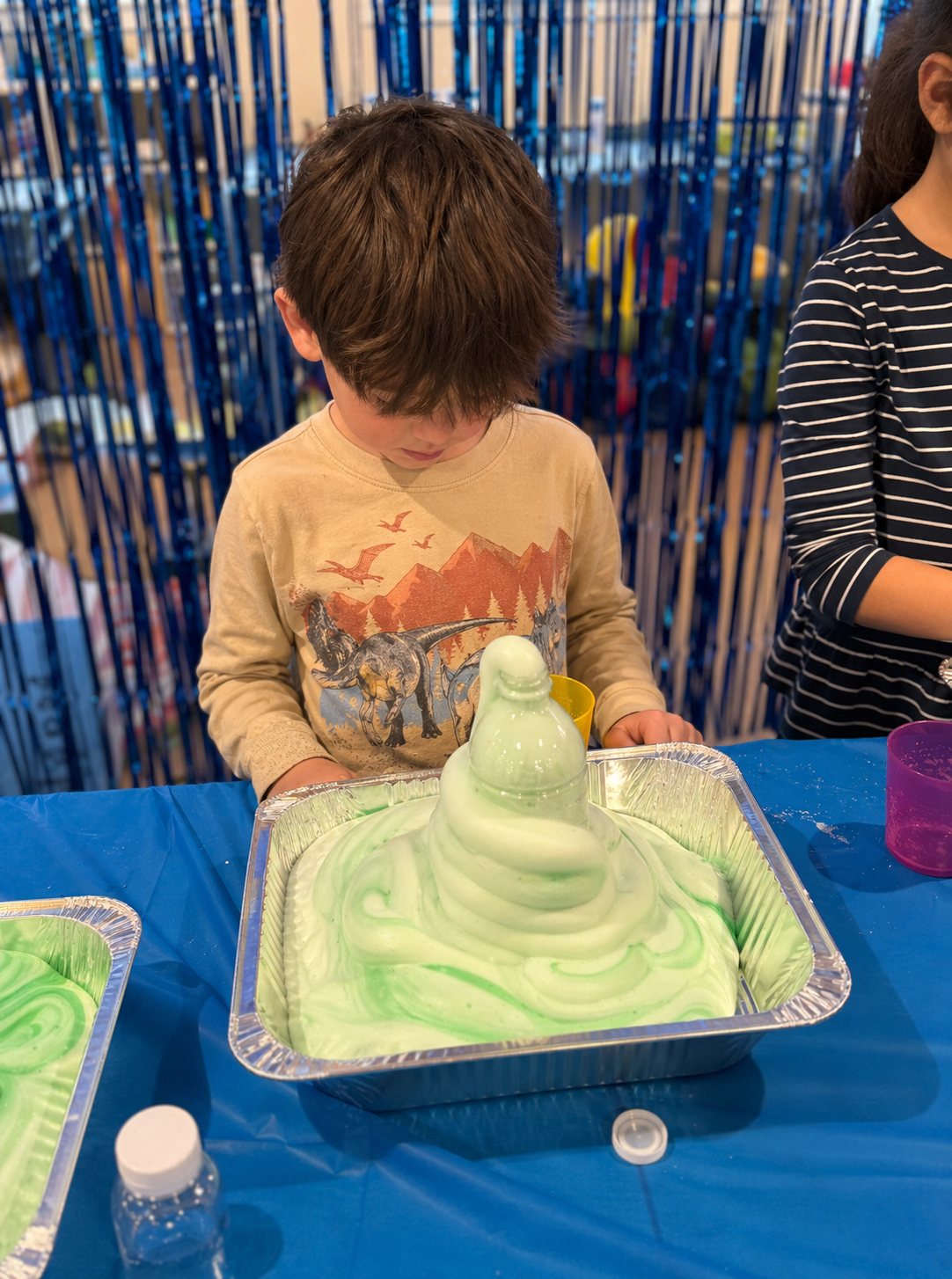 Child watching a baking soda volcano science experiment at camp